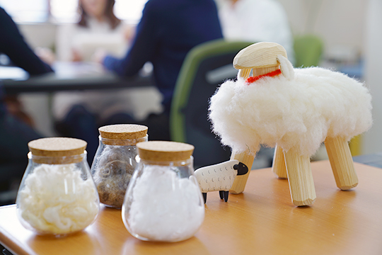羊毛のサンプルと羊の人形の写真